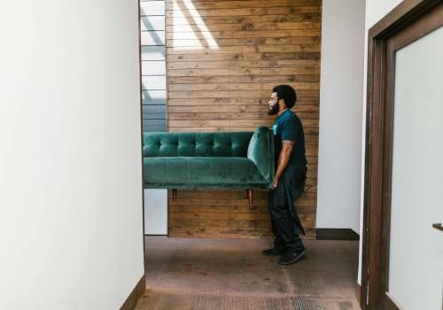 A person doing Furniture Relocation, moving a couch.