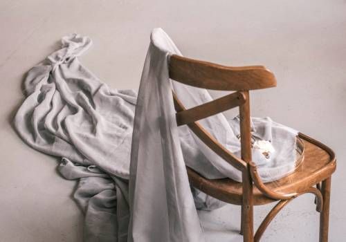 A wooden chair about to be wrapped with cloth.