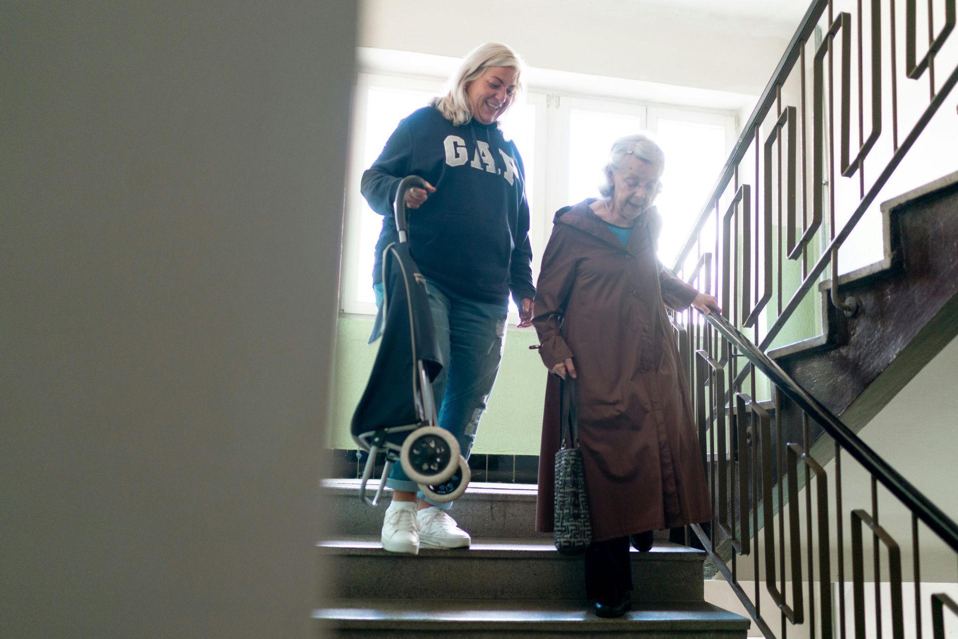 An old woman assisted by a younger woman