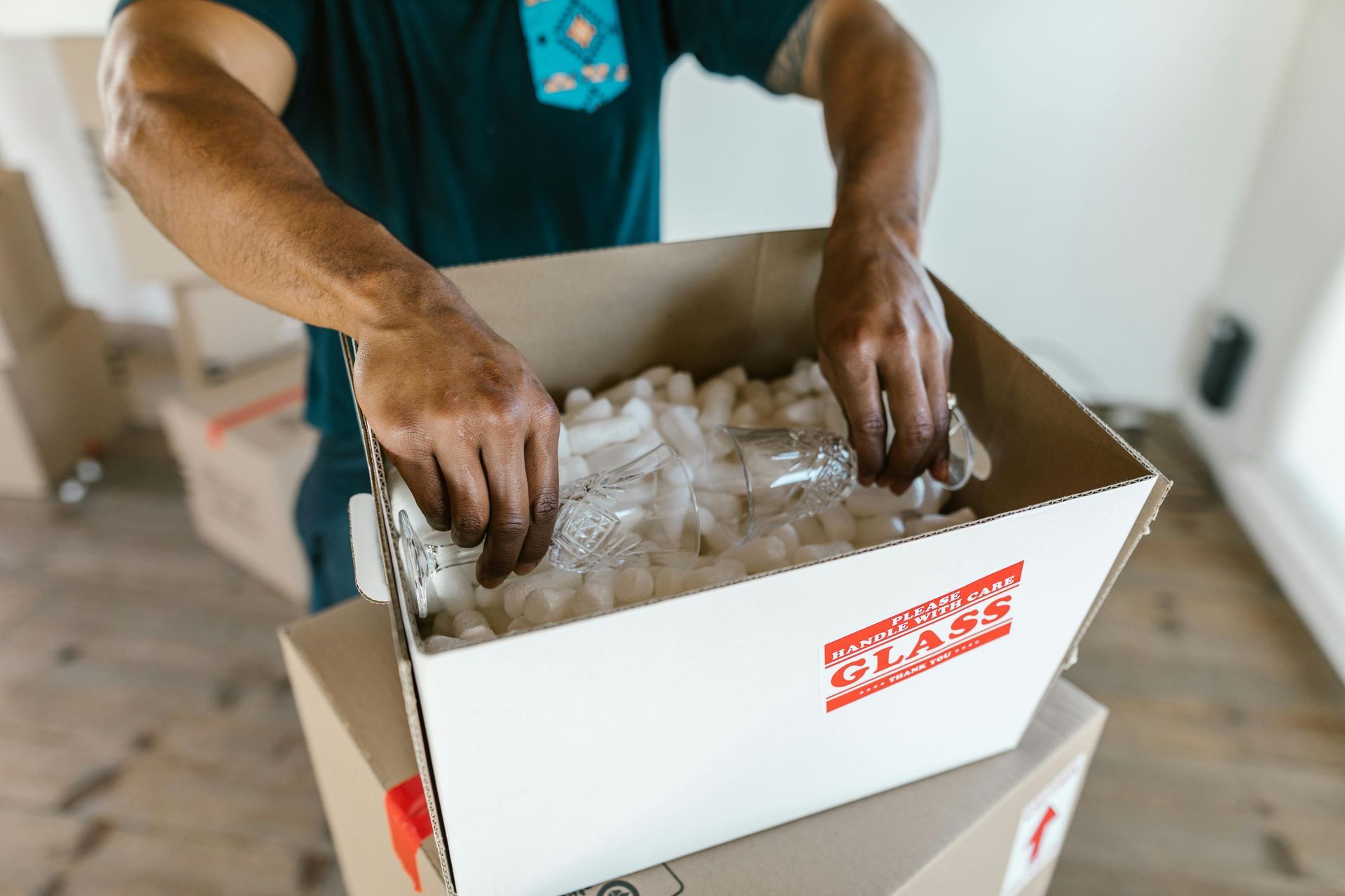A human holding a fragile labelled package.
