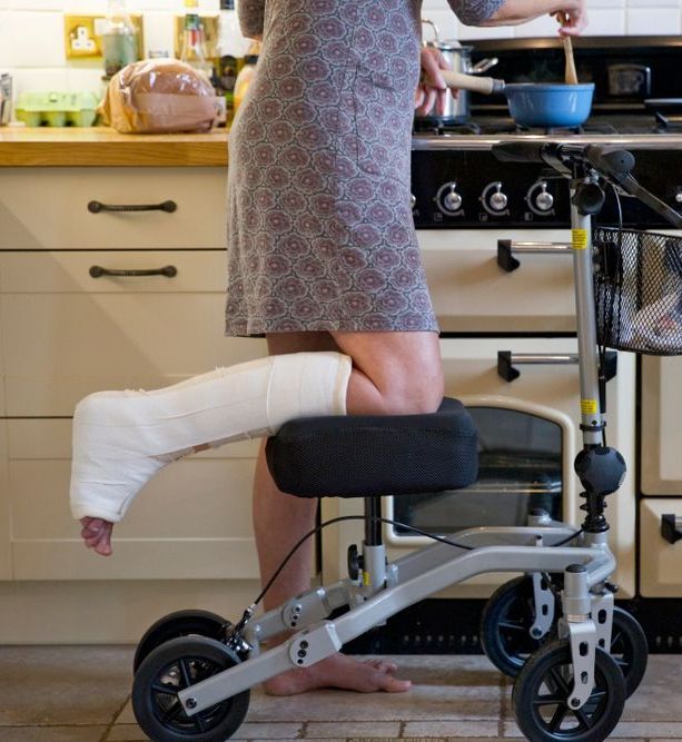 A Woman With A Cast On Her Leg Is Using A Knee Walker — Port Macquarie Physio & Pilates In Port Macquarie, NSW
