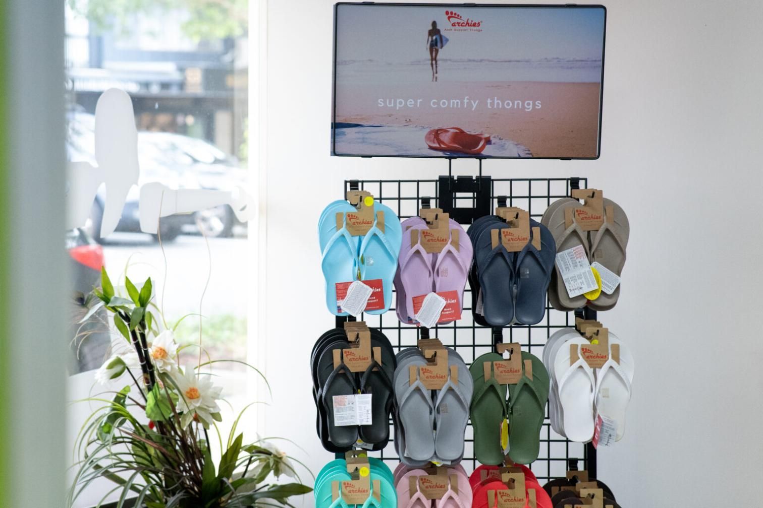 A Display Of Flip Flops Is Hanging On A Wall In A Store — Port Macquarie Physio & Pilates In Port Macquarie, NSW
