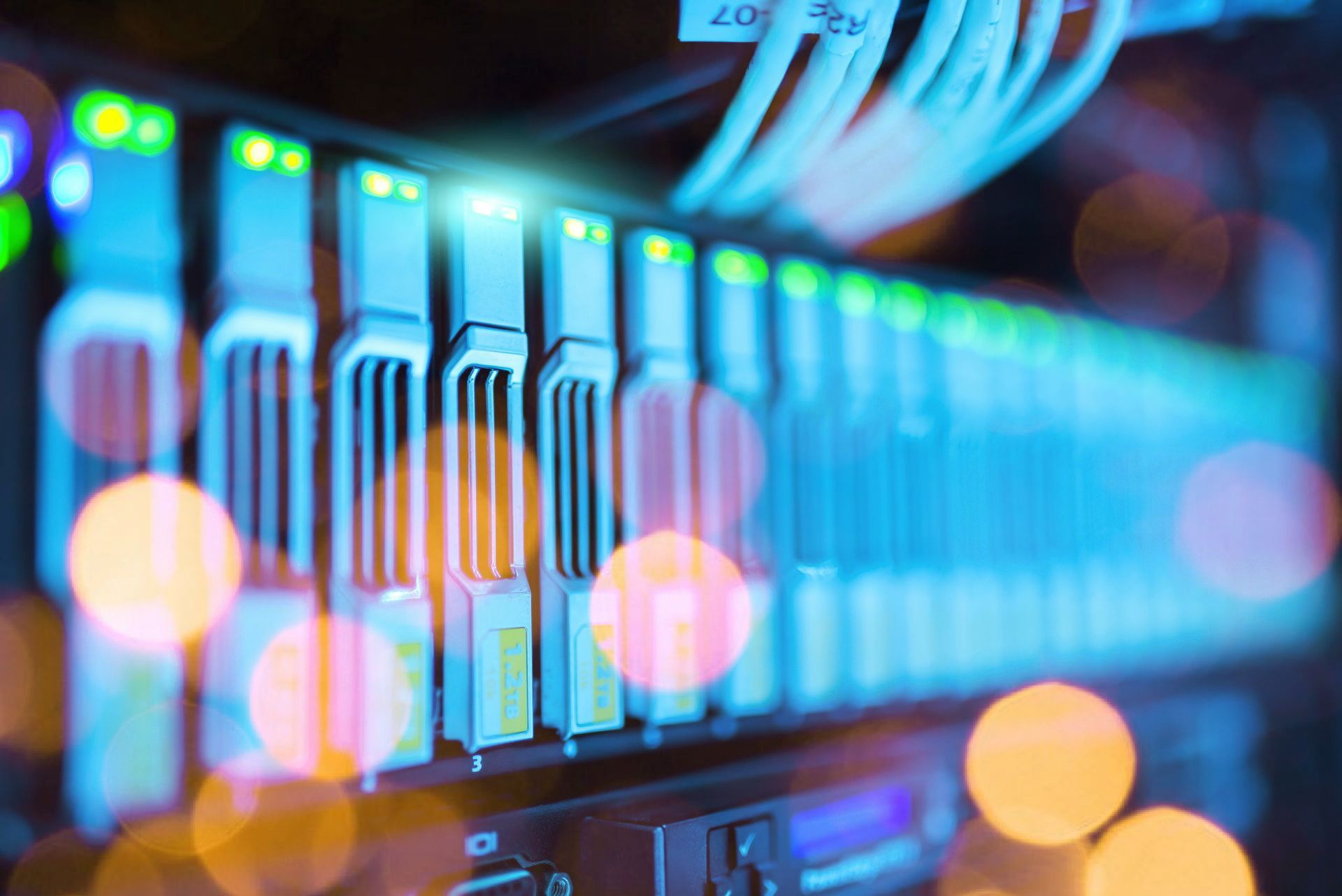 A close up of a server in a data center with a lot of wires coming out of it.