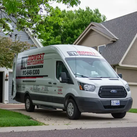 White Midwest Duct Cleaning van parked in front of a house on a sunny day.