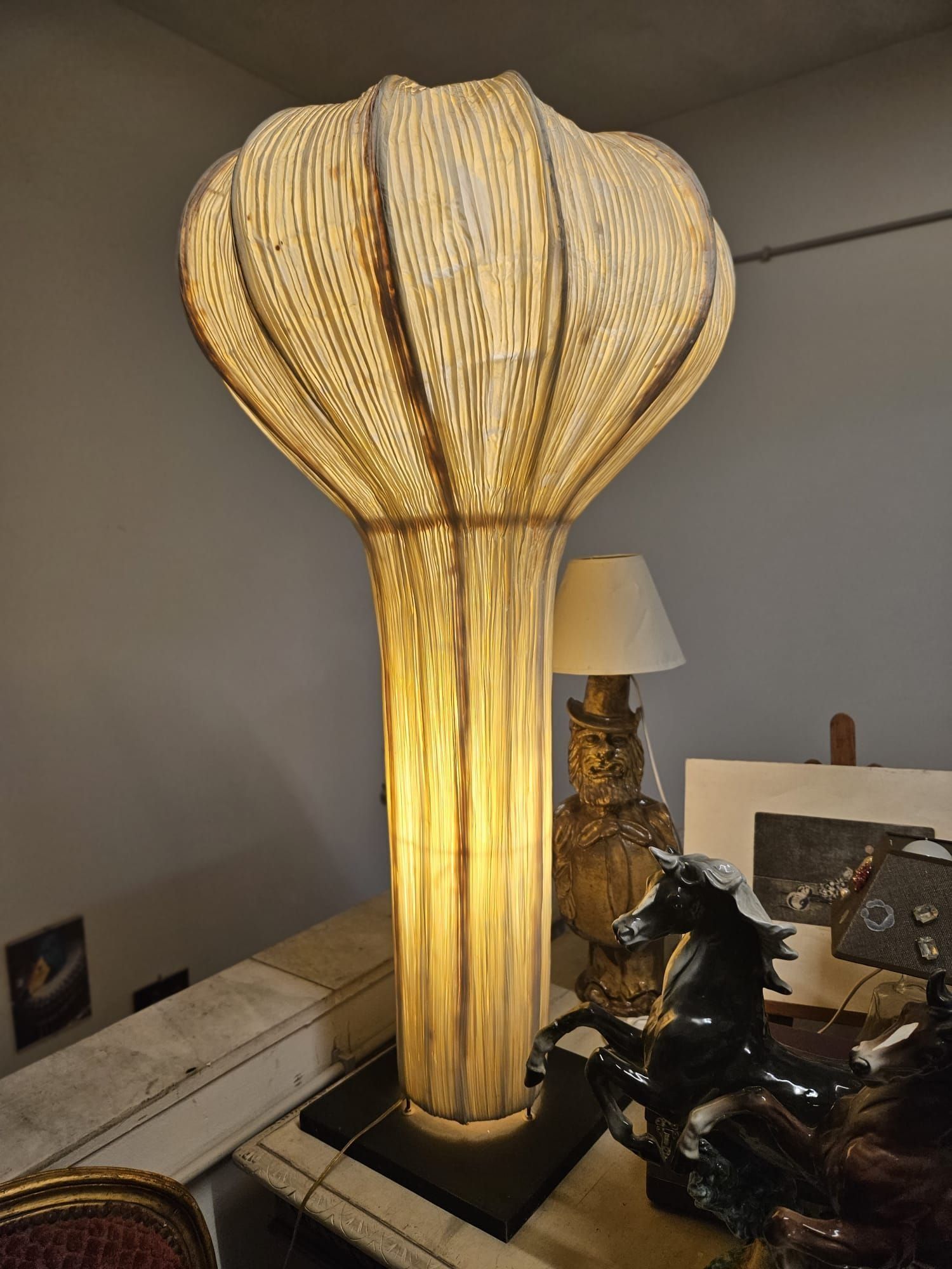 Vista interna di un'officina con impalcature, operai e macchinari. È visibile il soffitto a volta.