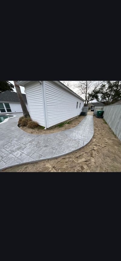 Curved gravel path beside a white lattice fence and shrubs in a yard