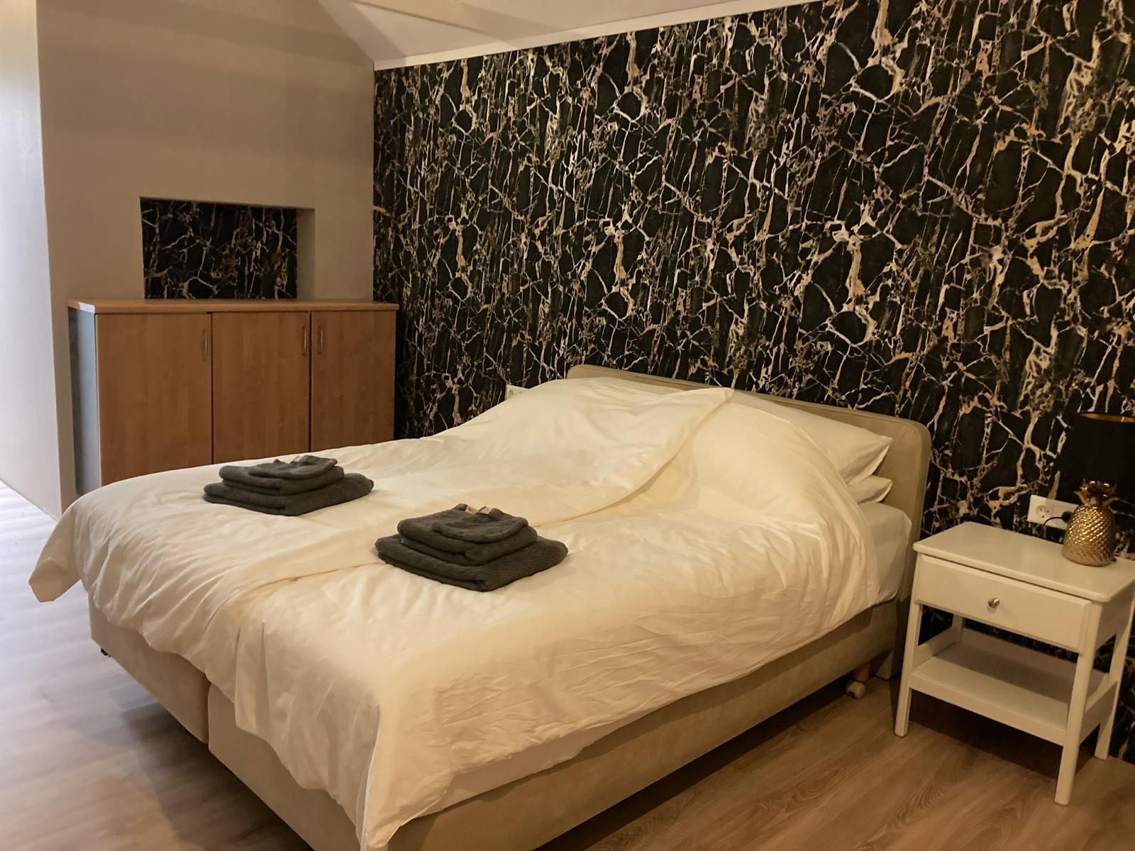 Een slaapkamer met een groot bed en een nachtkastje