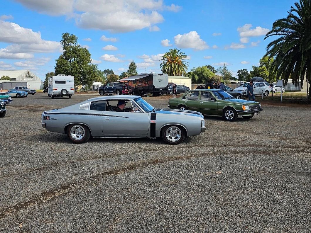 sliver car and green car driving next to each other 