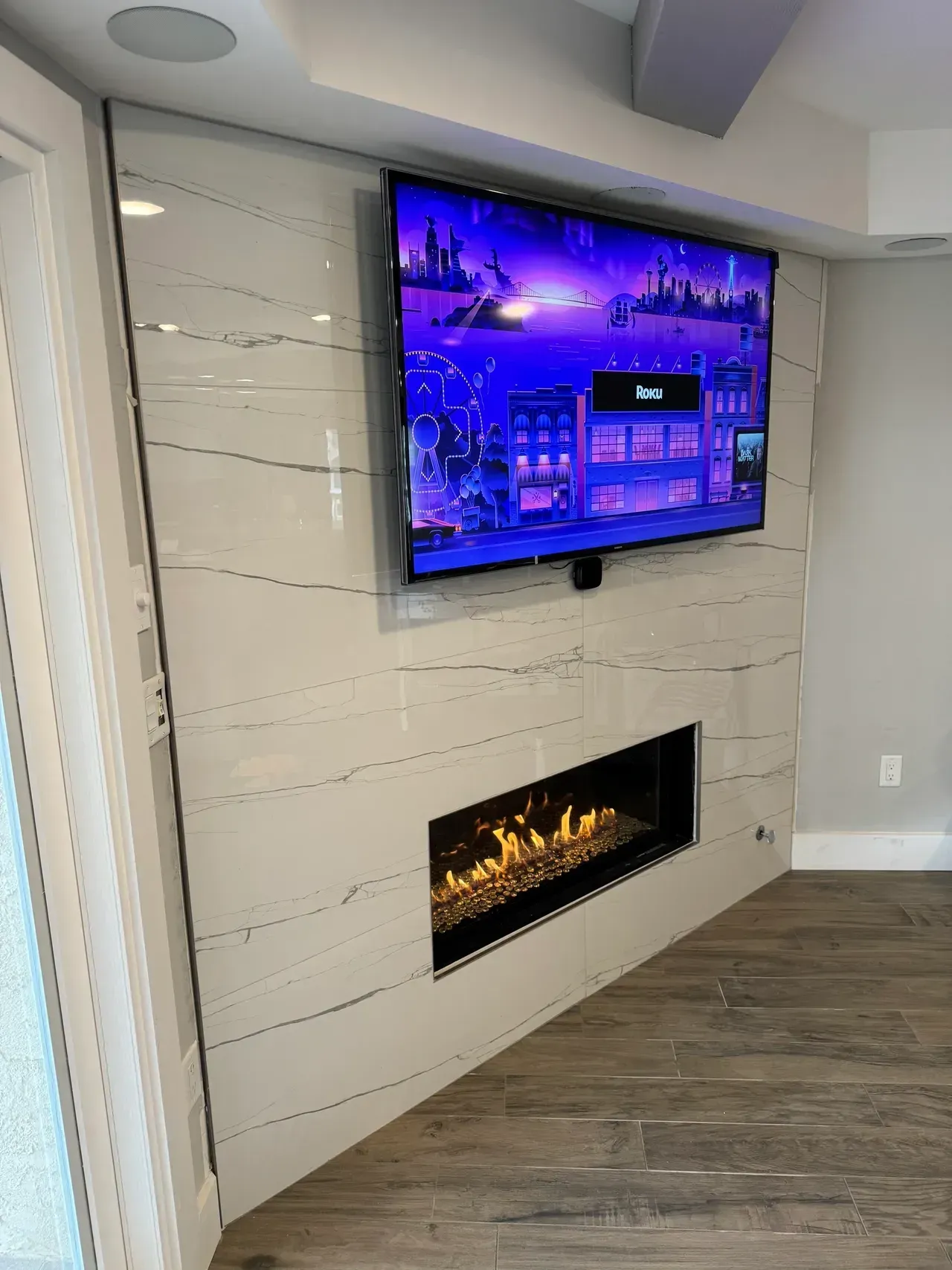 A living room with a fireplace and a flat screen tv mounted on the wall.
