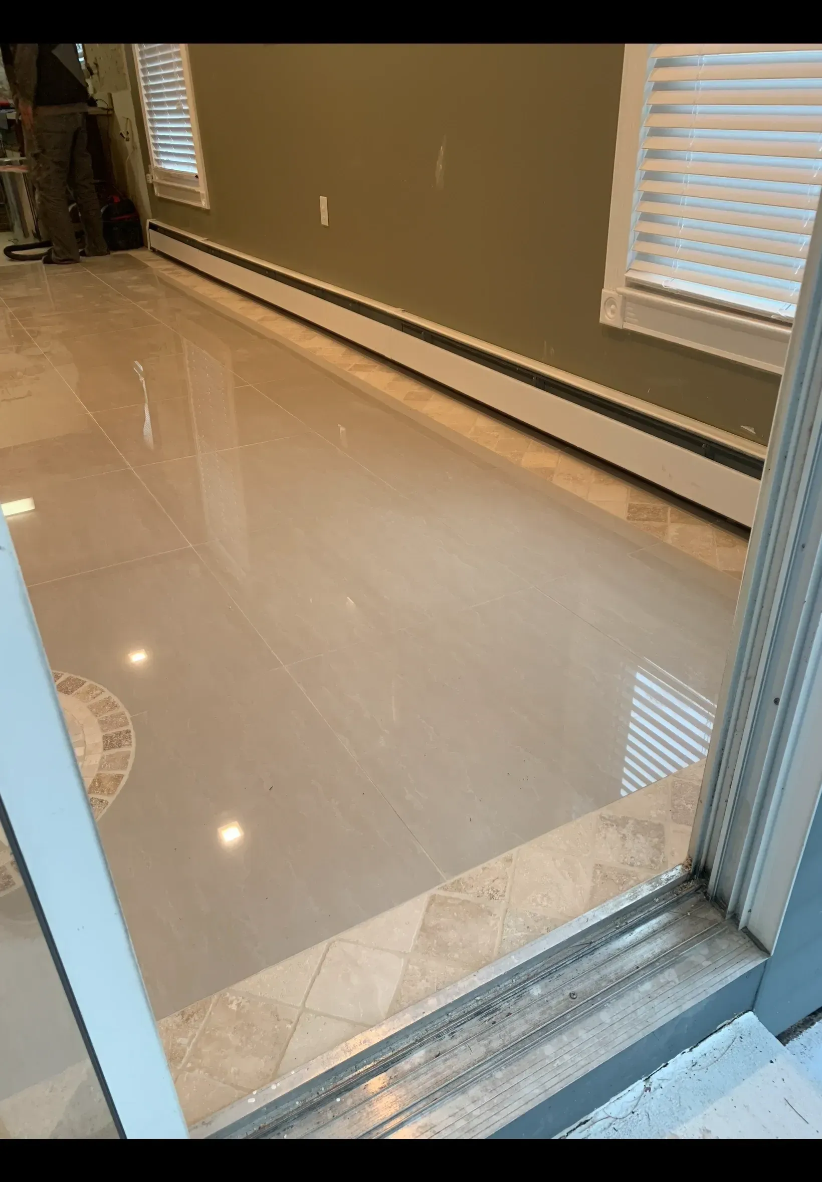 A room with a marble floor and a sliding glass door.