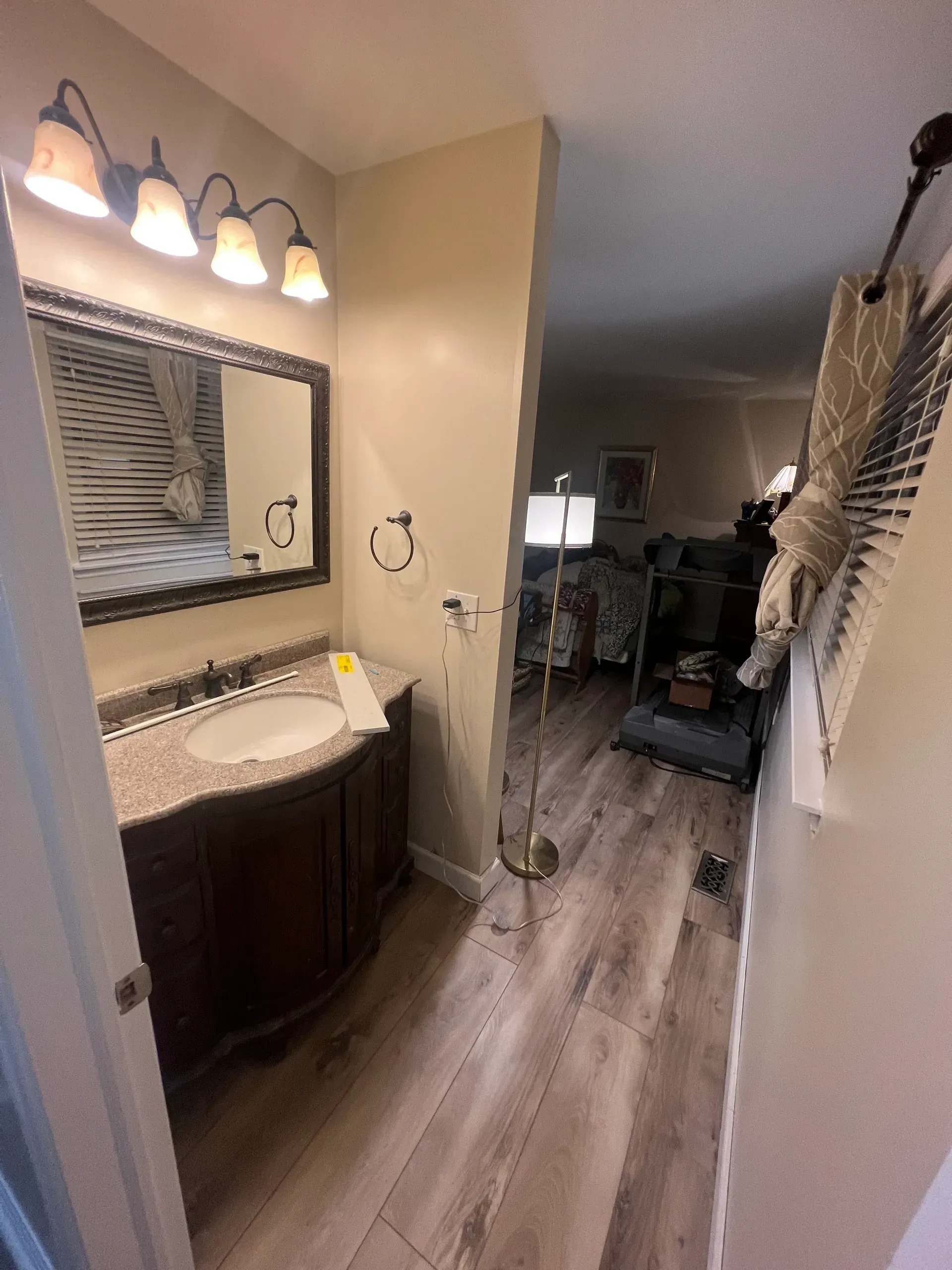 A bathroom with a sink , mirror and lamp.