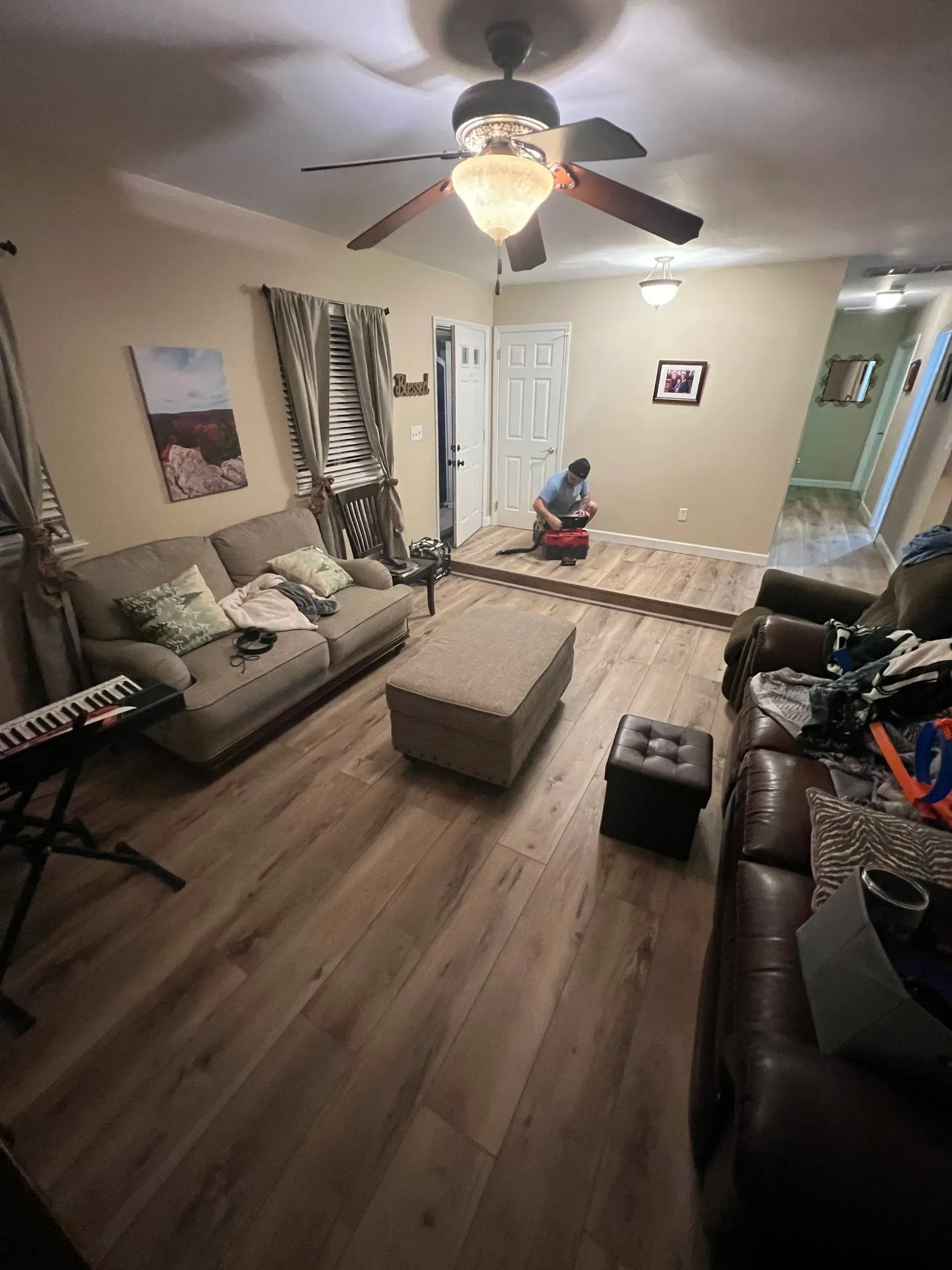 A living room filled with furniture and a ceiling fan.