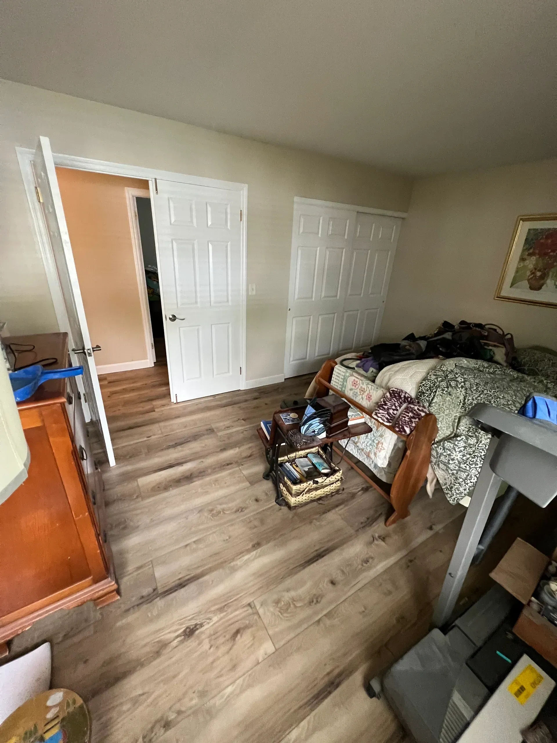 A bedroom with a treadmill and a bed.