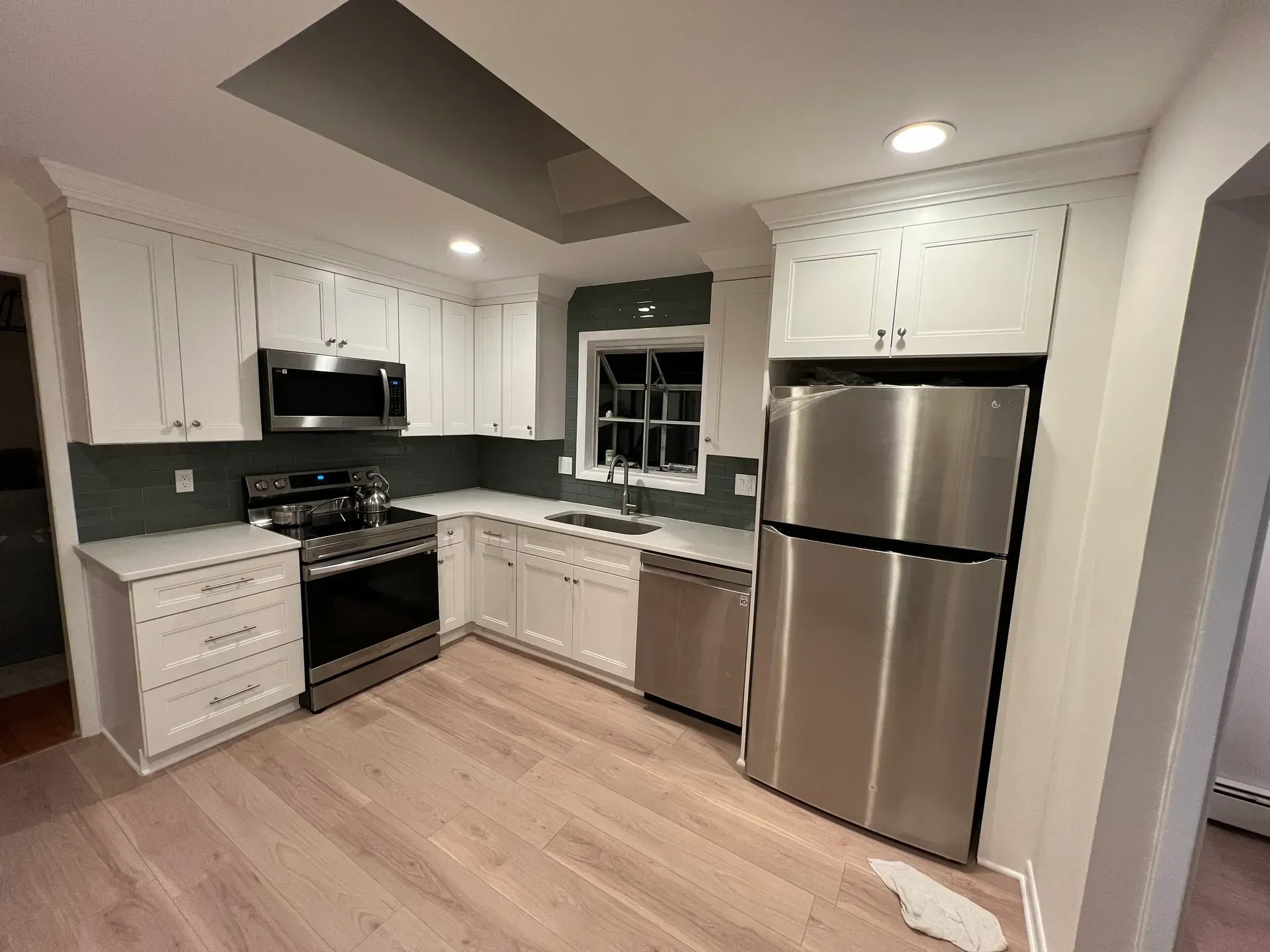 A kitchen with stainless steel appliances and white cabinets