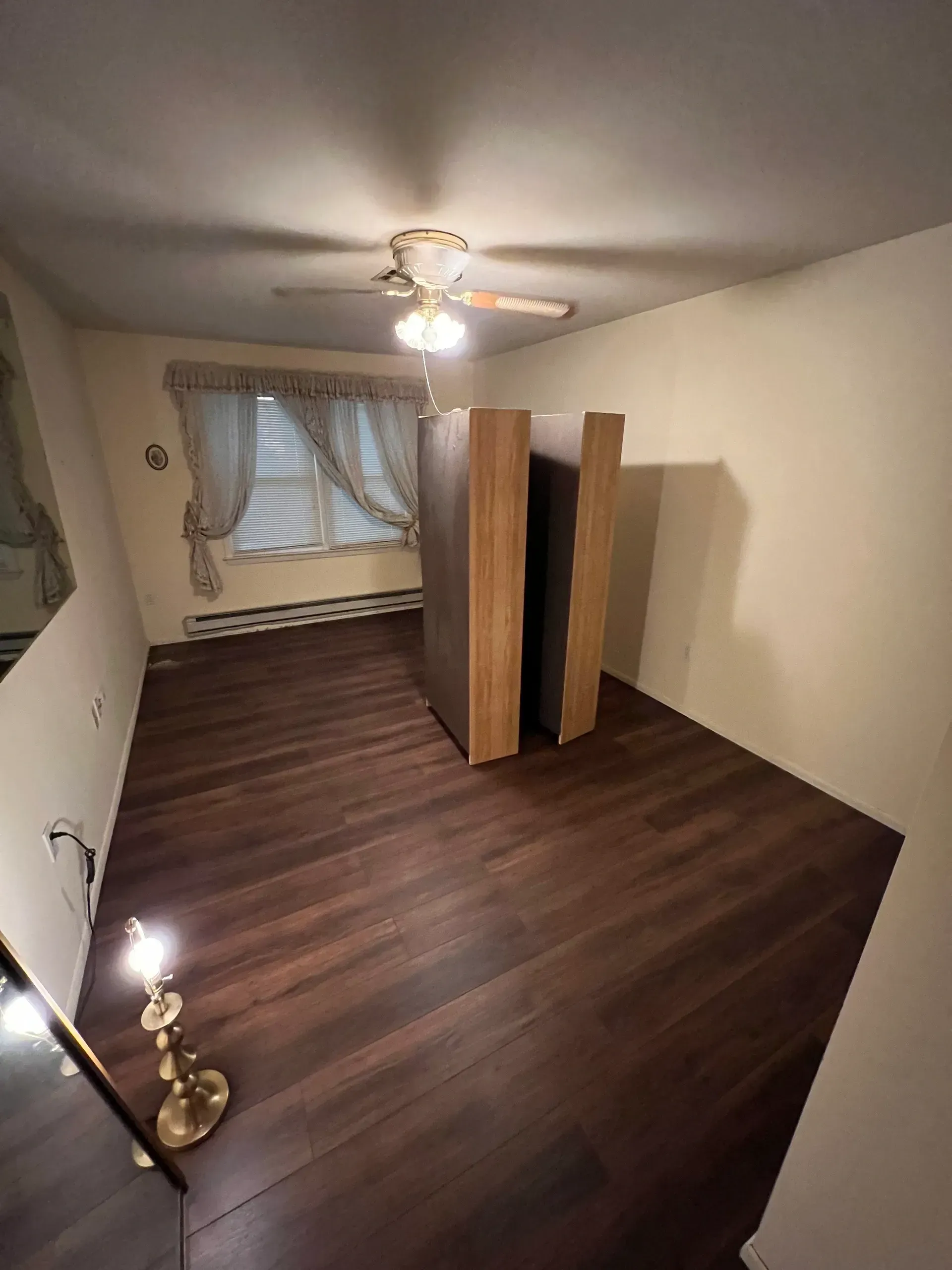 There is a ceiling fan in the room and a lamp on the floor.