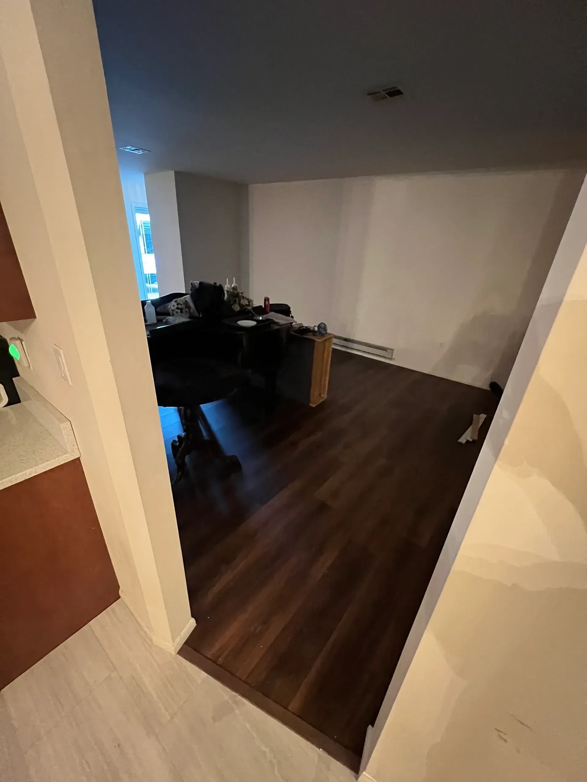 A room with a wooden floor and a desk in it.