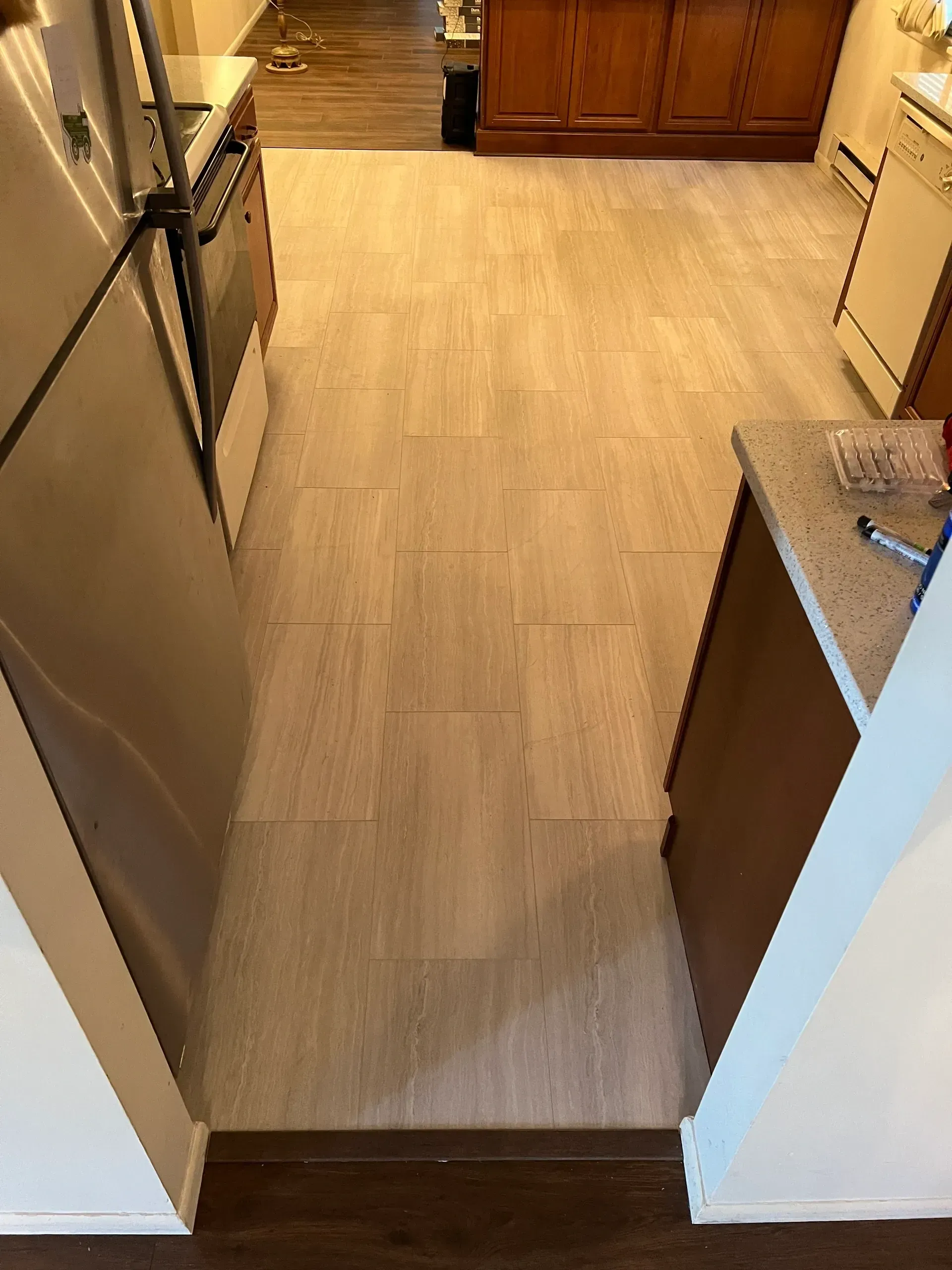 A kitchen with a stainless steel refrigerator , stove , and sink.