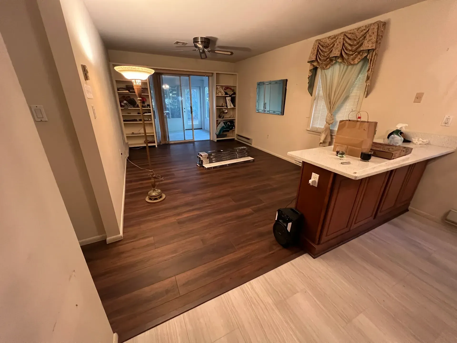 A living room with hardwood floors and a sliding glass door.