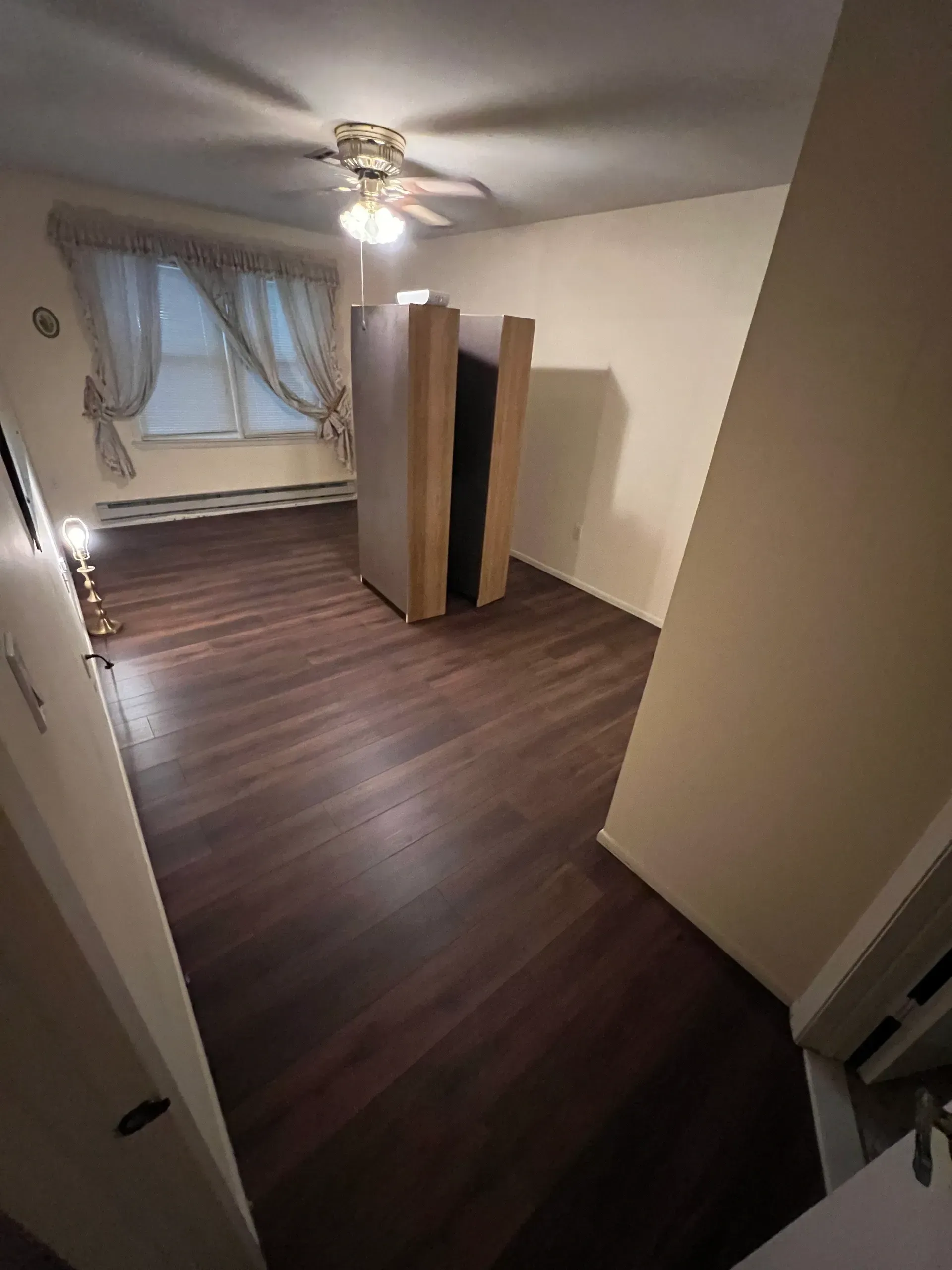 A living room with hardwood floors and a ceiling fan.