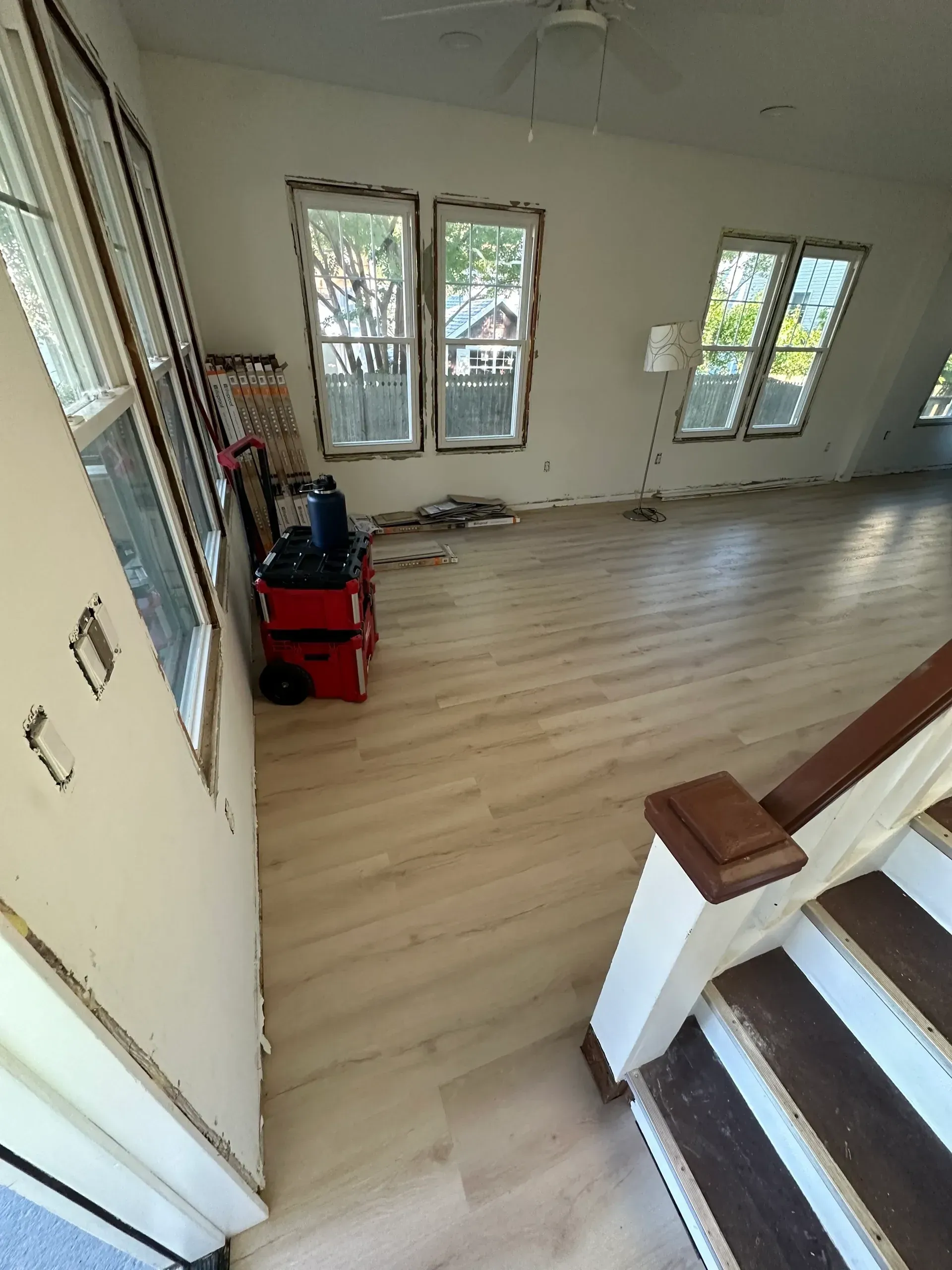 An empty room with stairs and a lot of windows