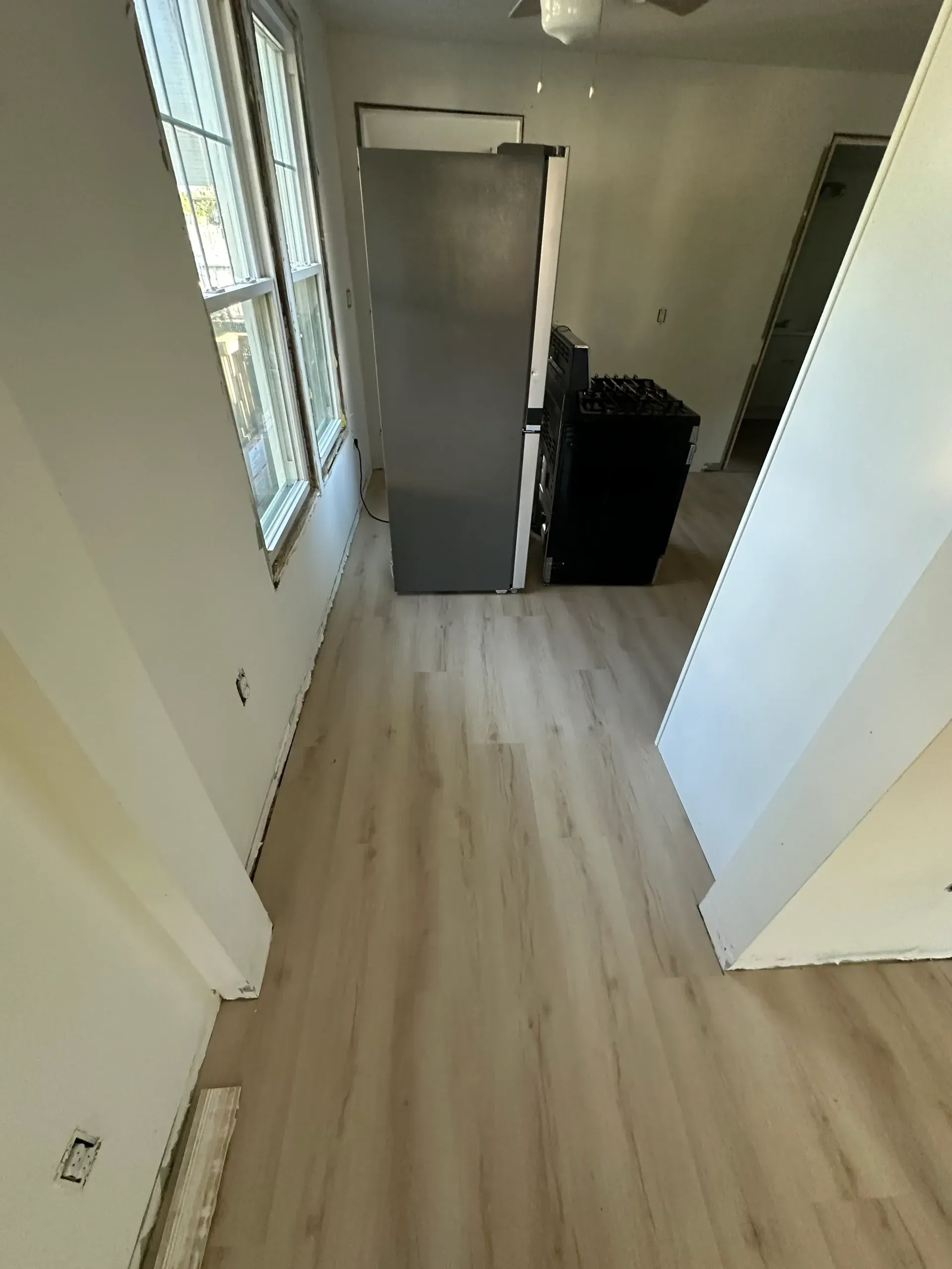 A kitchen with hardwood floors and a refrigerator.
