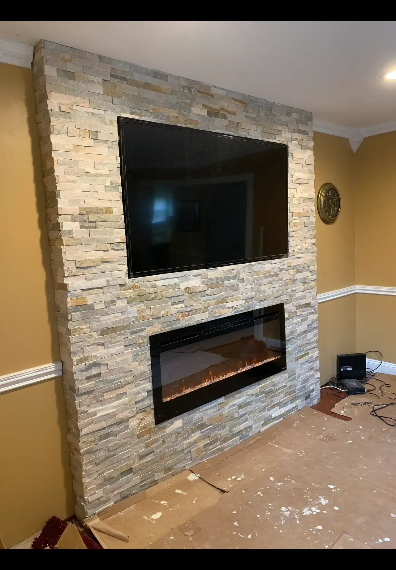 A living room with a fireplace and a flat screen tv mounted on the wall.