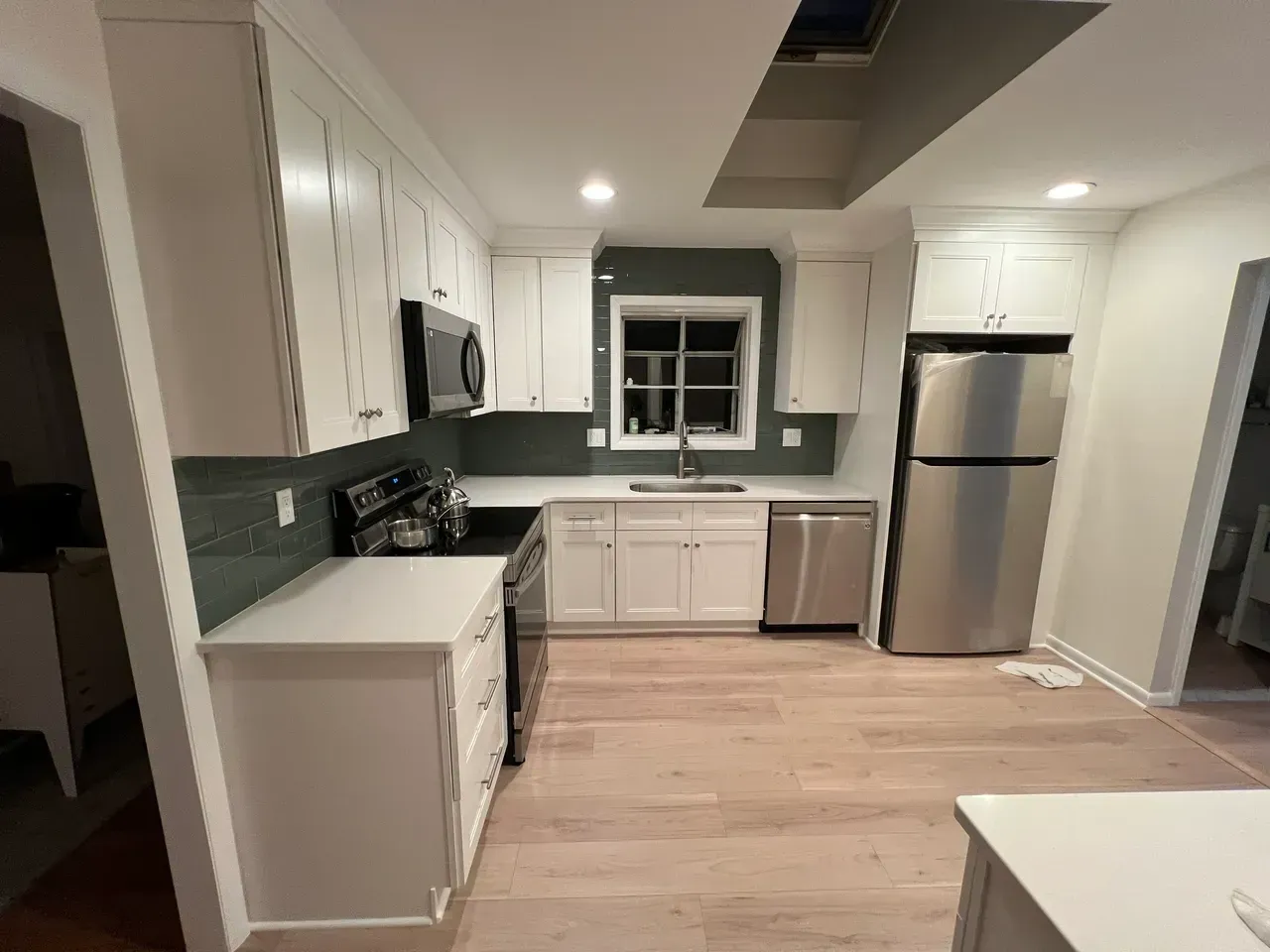 A kitchen with white cabinets and stainless steel appliances.