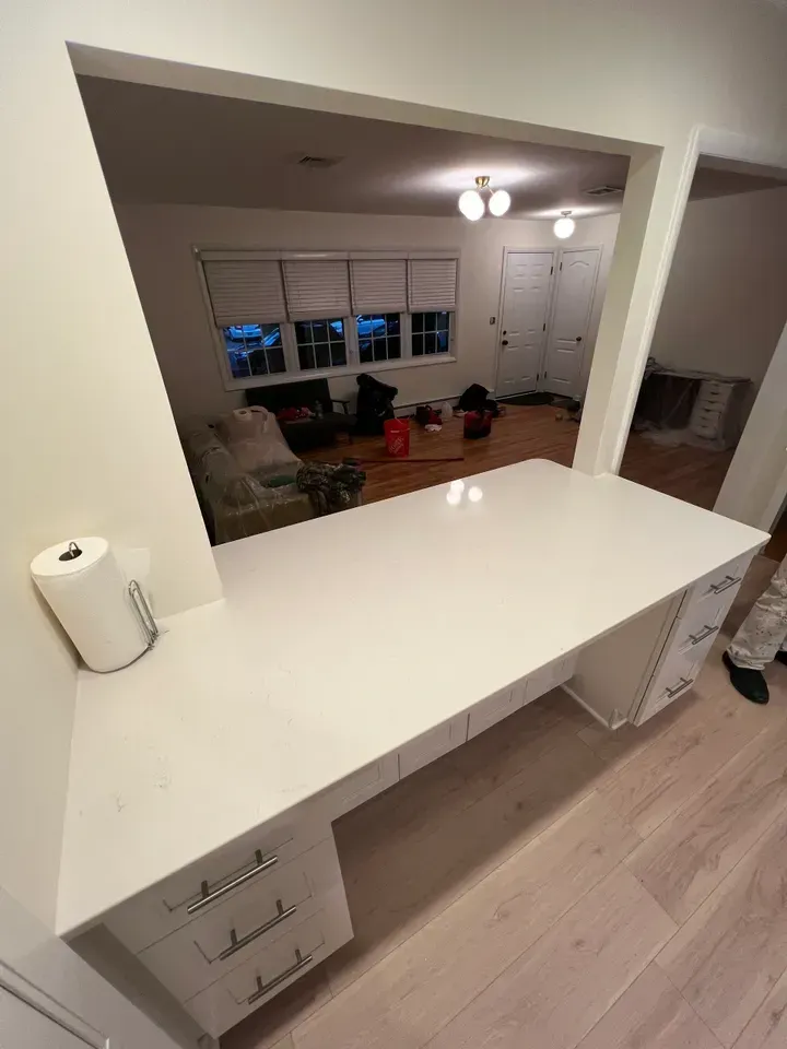 A white desk in a room with a paper towel on it.