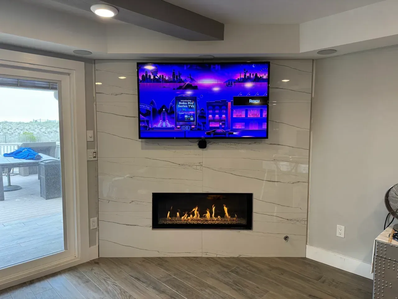 A living room with a fireplace and a flat screen tv on the wall.