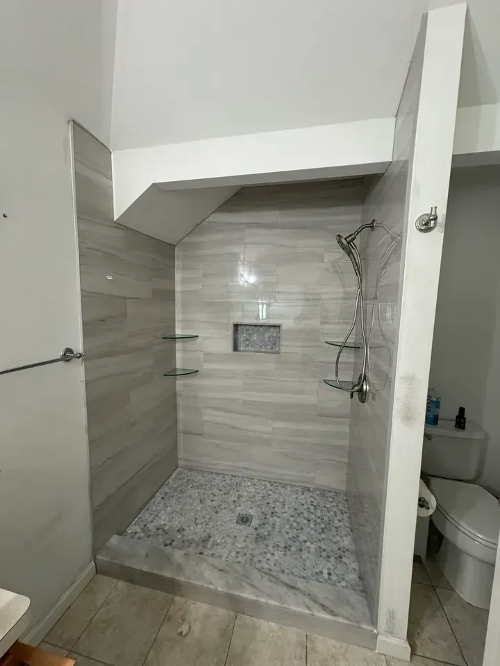 A bathroom with a walk in shower and a toilet.