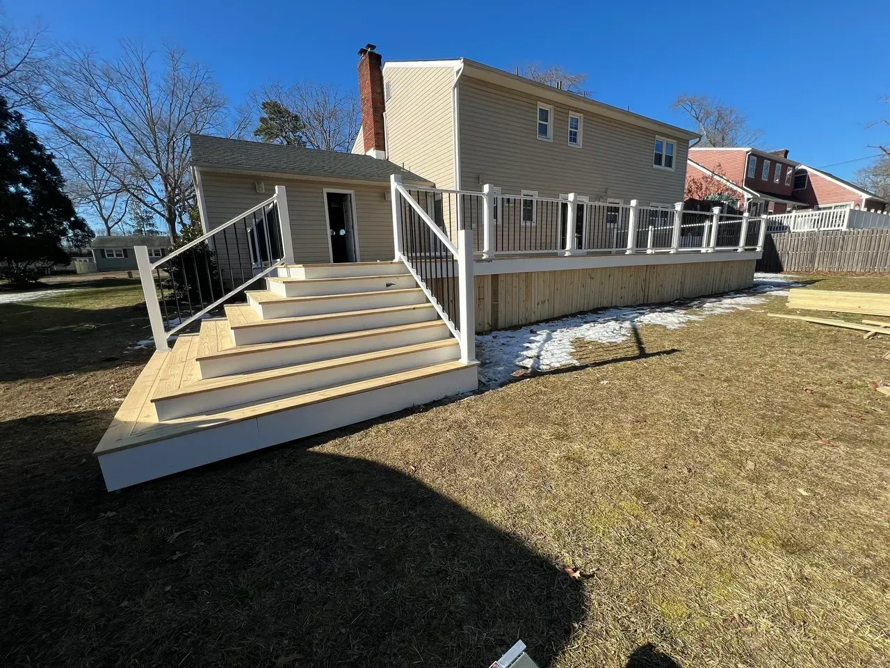 A house with a deck and stairs in the backyard