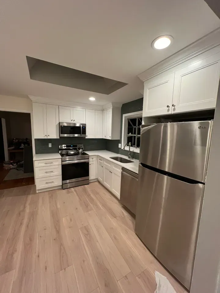 A kitchen with stainless steel appliances and white cabinets.
