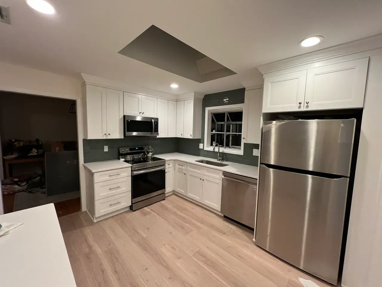 A kitchen with stainless steel appliances and white cabinets.