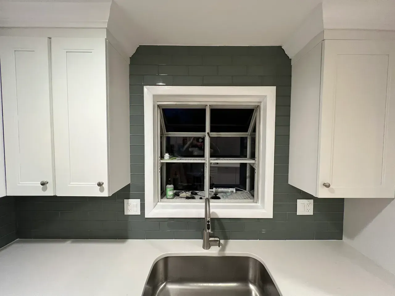 A kitchen with a sink and a window above it