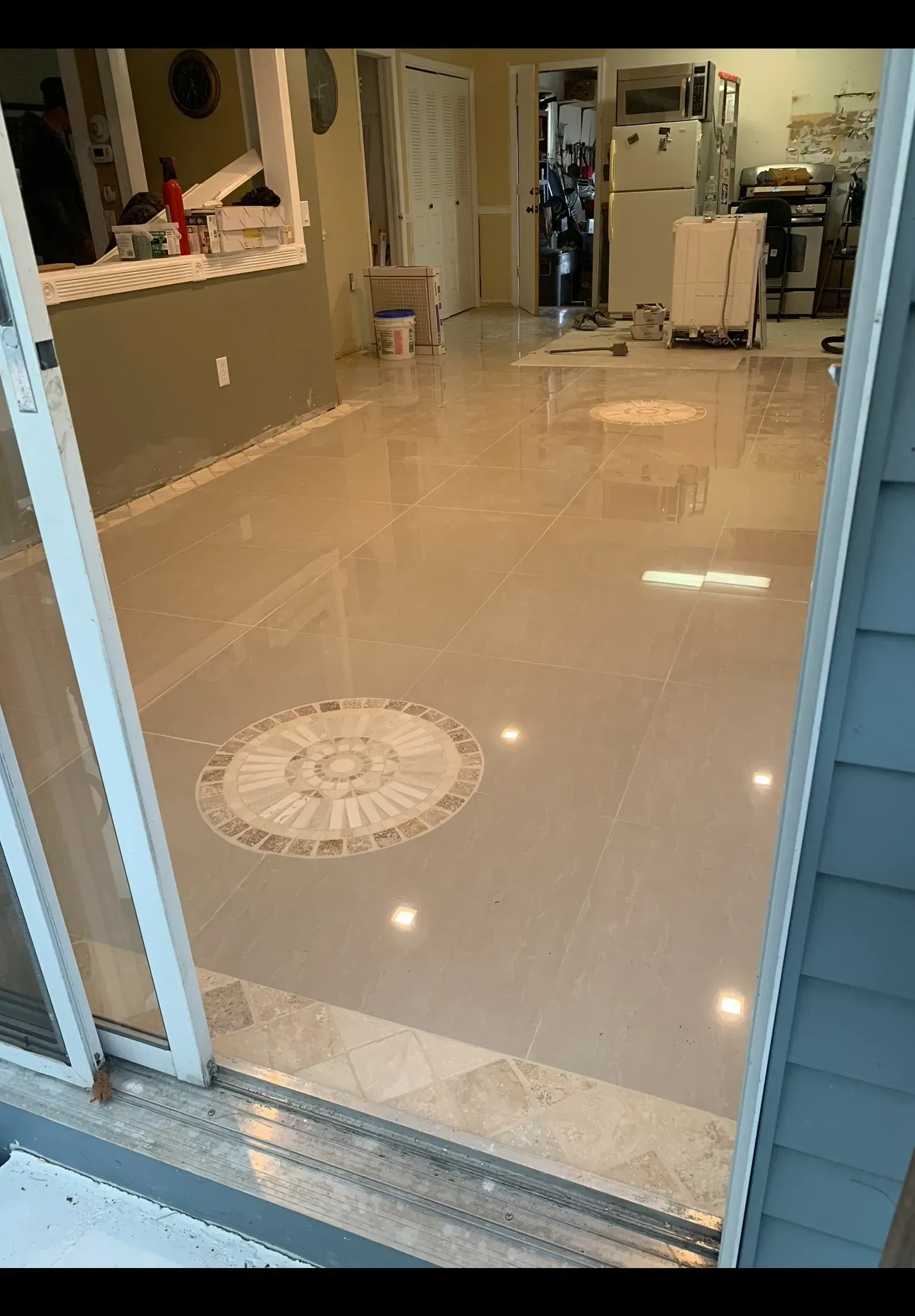 A living room with a marble floor and a sliding glass door.
