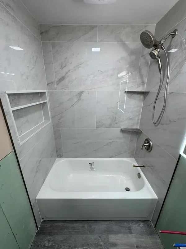 A bathroom with a bathtub and a shower.