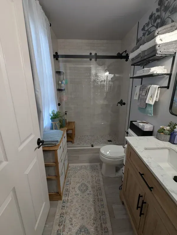 A bathroom with a toilet , sink , and shower.