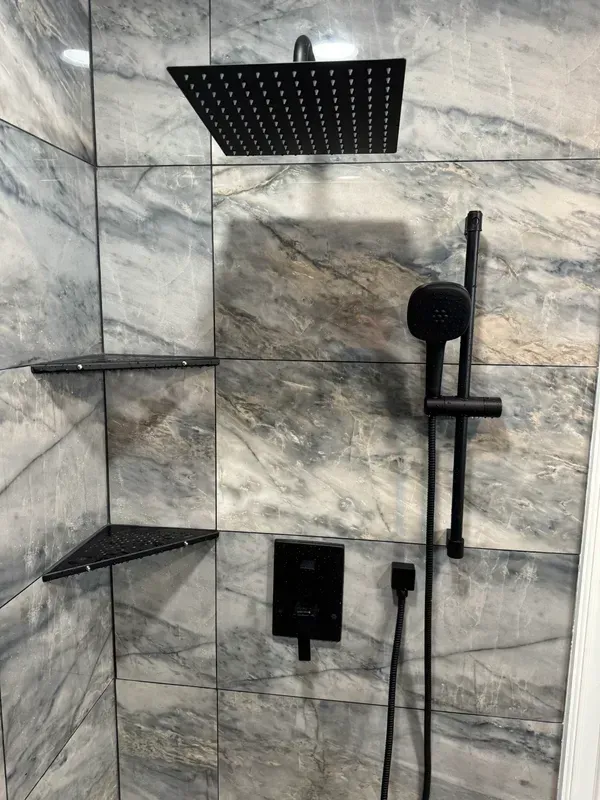 A shower with a black shower head and a black shower head.