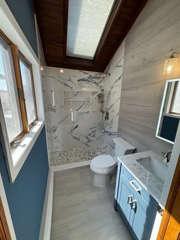 A bathroom with a toilet , sink , and shower.