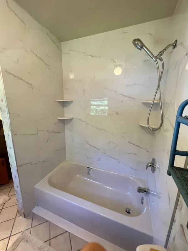 A bathroom with a bathtub and a shower.