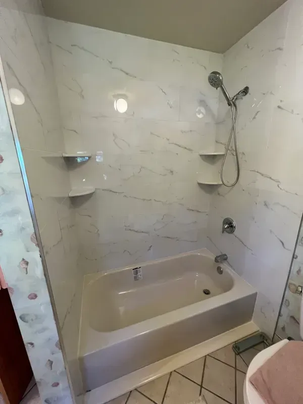 A bathroom with a bathtub and a shower.