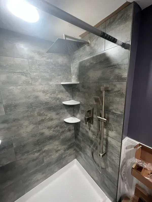 A bathroom with a shower , tub and shelves.