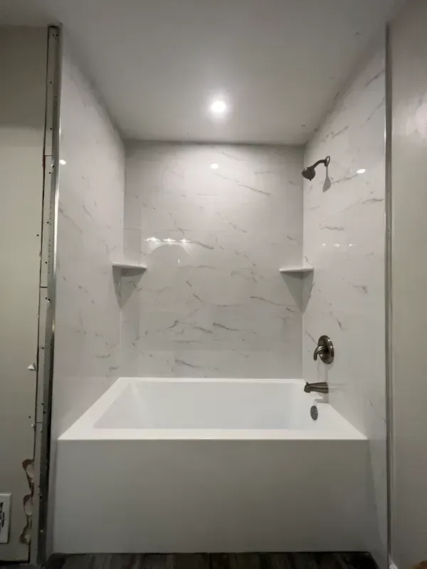 A bathroom with a bathtub and a shower.
