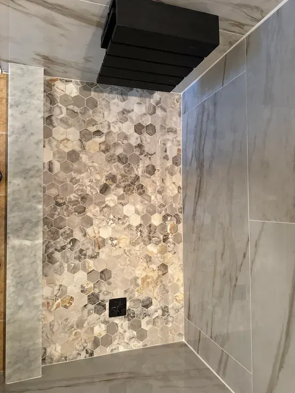 A bathroom with a walk in shower and a tiled floor.