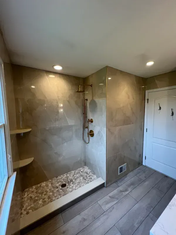 A bathroom with a walk in shower and a window.