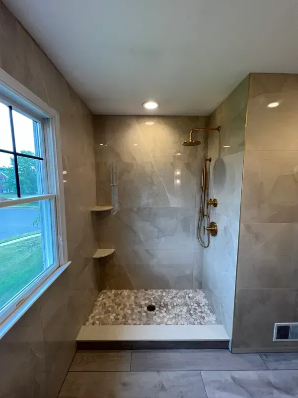 A bathroom with a walk in shower and a window.
