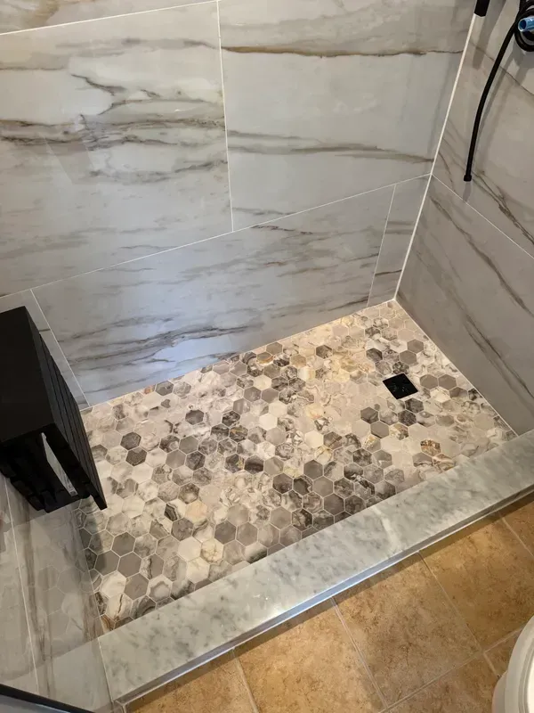 A bathroom with a walk in shower and a toilet.