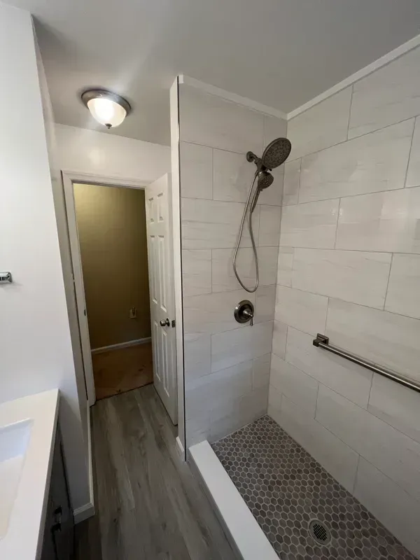 A bathroom with a walk in shower and a sink.