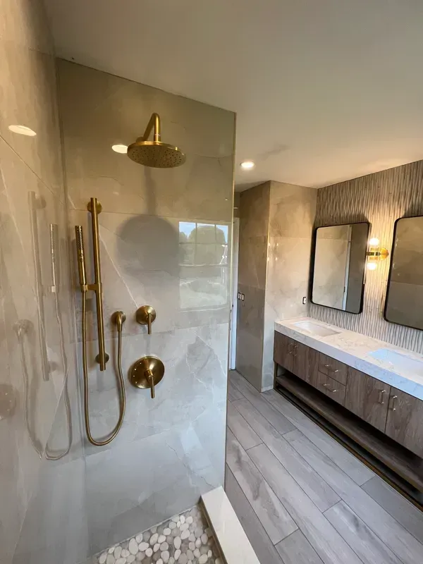 A bathroom with a walk in shower and a sink.