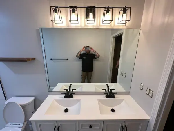 A man is taking a picture of himself in a bathroom mirror